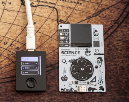 The Oxocard Connect (left) is much smaller than the Oxocard Mini. The joystick is trickier to use than the large direction buttons.
