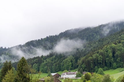 Een bewolkte lucht ligt boven de uitlopers van de Alpen.